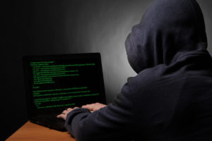 Hacker-With-Hoodie-on-Laptop-Dark
