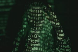 Hooded hacker indicates Navigating Cyber Threats