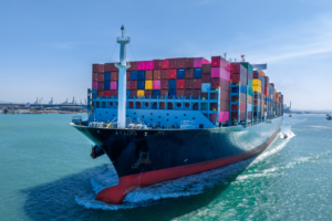 Container ship loaded with colorful cargo containers navigating through a busy port, emphasizing the importance of safeguarding your supply chain