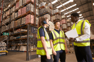 Warehouse workers in safety vests managing inventory in food distribution chain facility